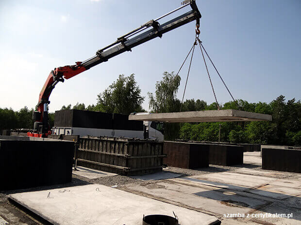 Załadunek szczelnego szamba betonowego do transportu  w Poddębicach